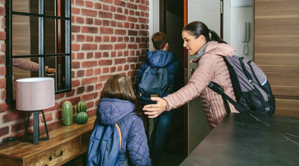 Family with emergency backpacks leaving their front door quickly