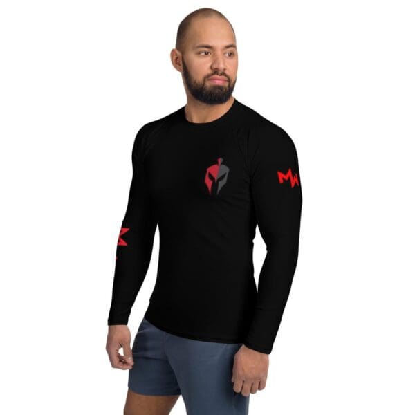 A MW Combatives man sporting a black long-sleeve MW Combatives Men's Rash Guard with a red logo.