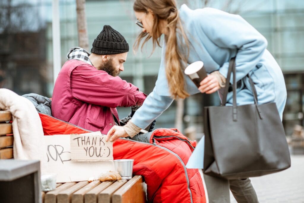 Homeless beggar with young business woman