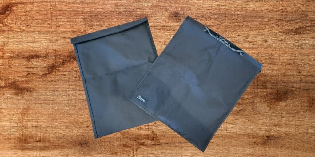 Two black plastic bags on a wooden surface providing electronic shielding.