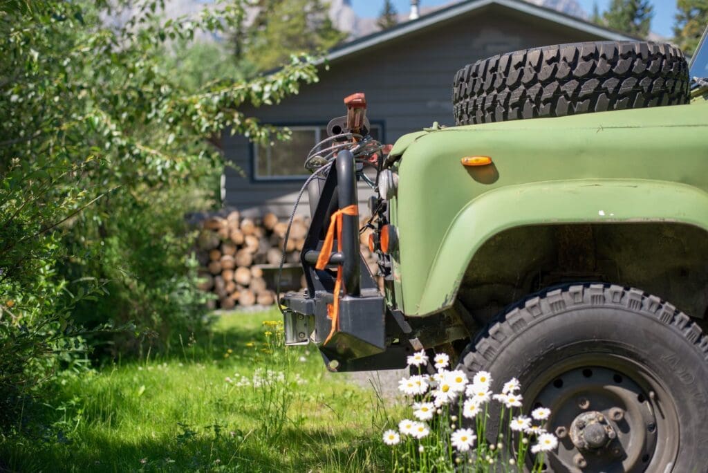 Off-road vehicle parked in front of cabin in the mountains