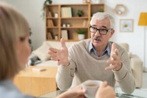 Retired man explaining something to his young daughter during discussion