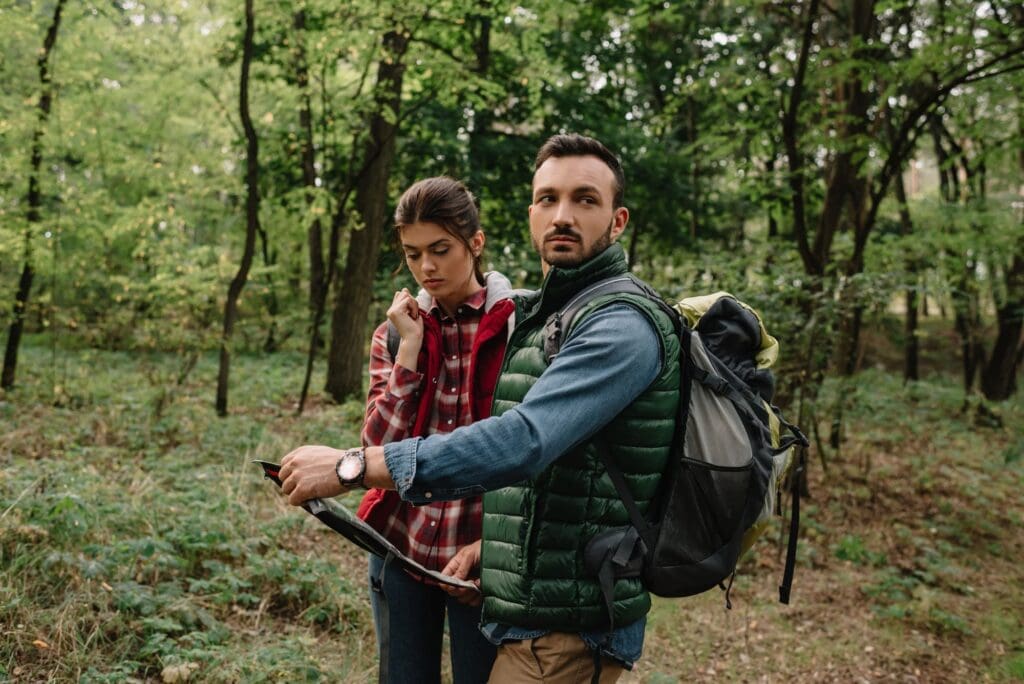 couple of travelers with map got lost in woods