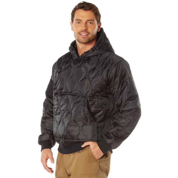 A person in a 2XL black quilted woobie hooded sweatshirt and khaki pants stands with a hand in the pocket.