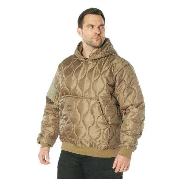 A man wearing a Rothco brown quilted woobie hoodie with a front pocket stands, looking to the side against a white background.