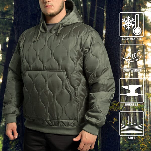 A person in a green woobie hoodie stands in a forest, surrounded by nature. Icons on the side highlight that the quilted sweatshirt is ideal for cold weather, offering lightweight durability and softness.